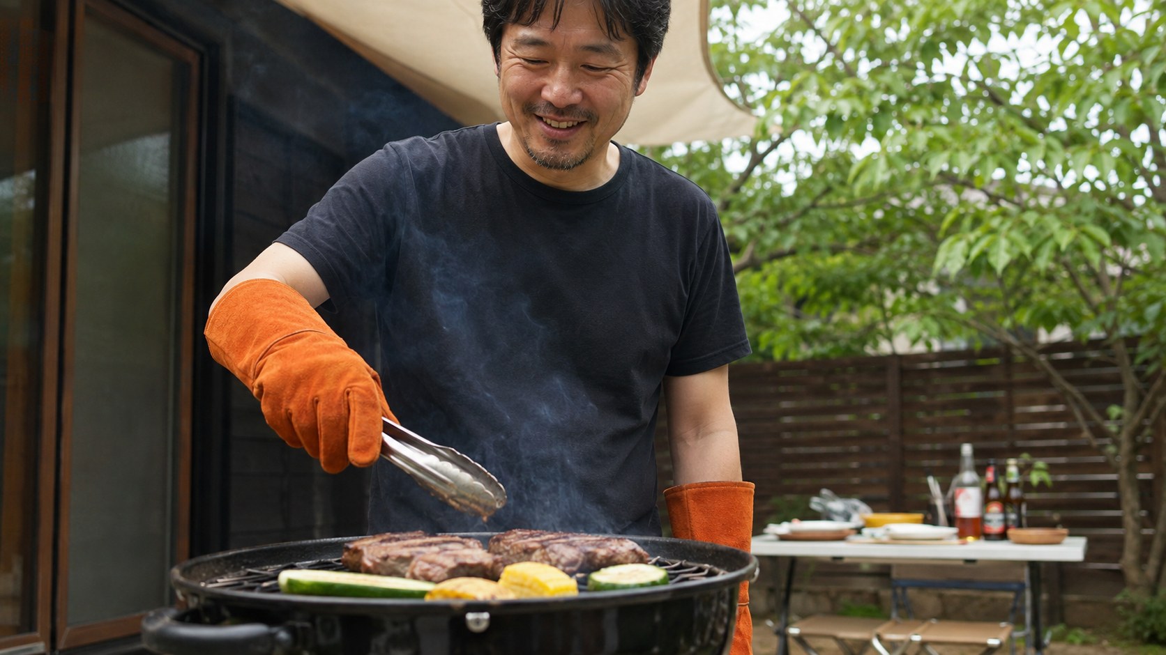 BBQで耐熱グローブをつけて炭を扱う男性